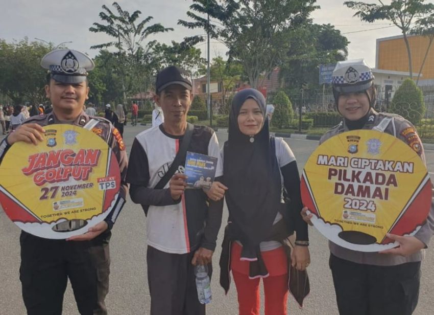 Rangkul Masyarakat Ciptakan Pilkada Damai, Personel Satlantas Polresta Pekanbaru Bagikan Brosur dan Stiker di Sekitaran Car Free Day